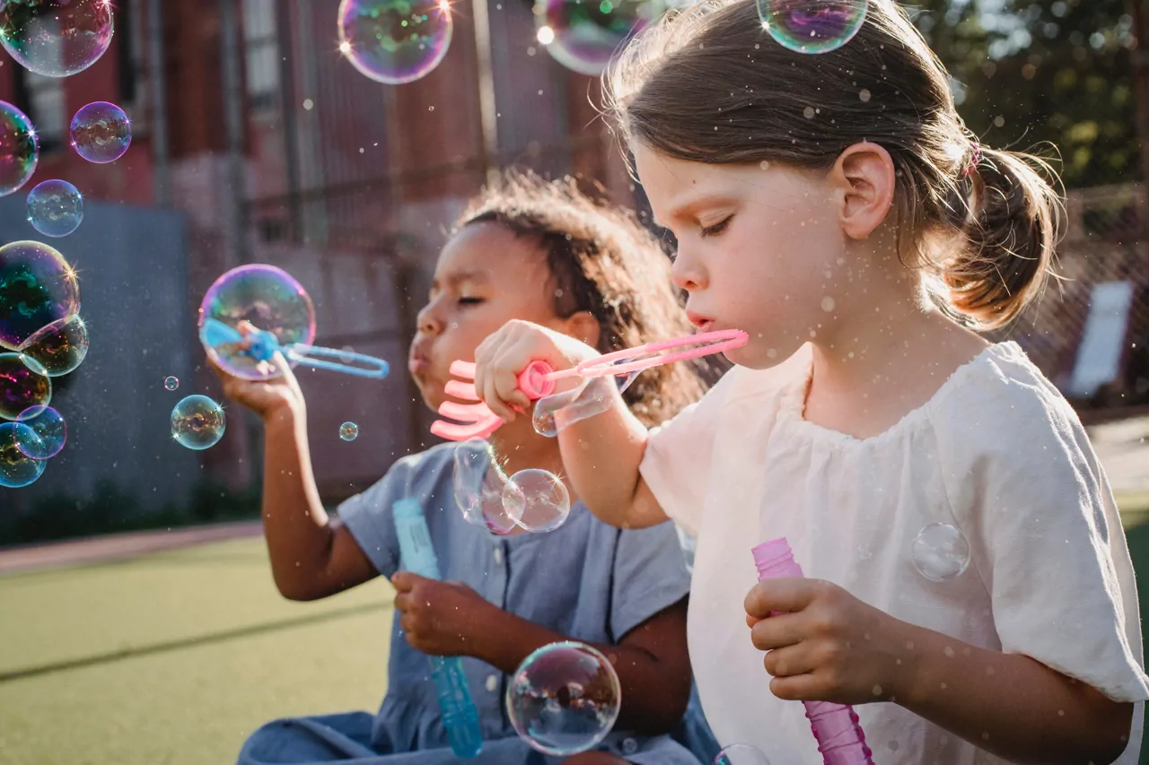 Two children blowing bubbles