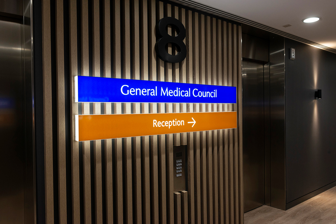 Lift area with two signs one reading general medical council and the other reading reception