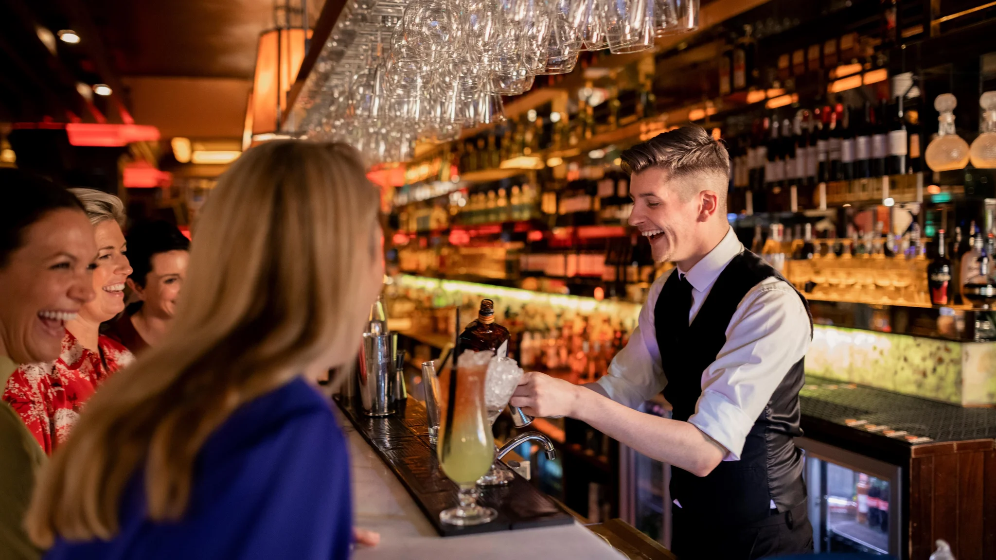 Bartender serving customers and laughing