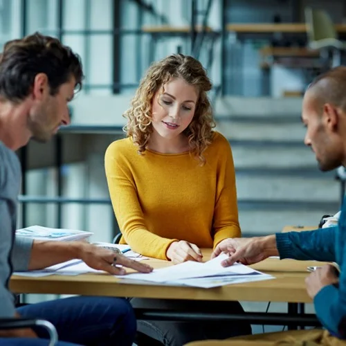 Cost Management image Three business people looking at documents on a desk