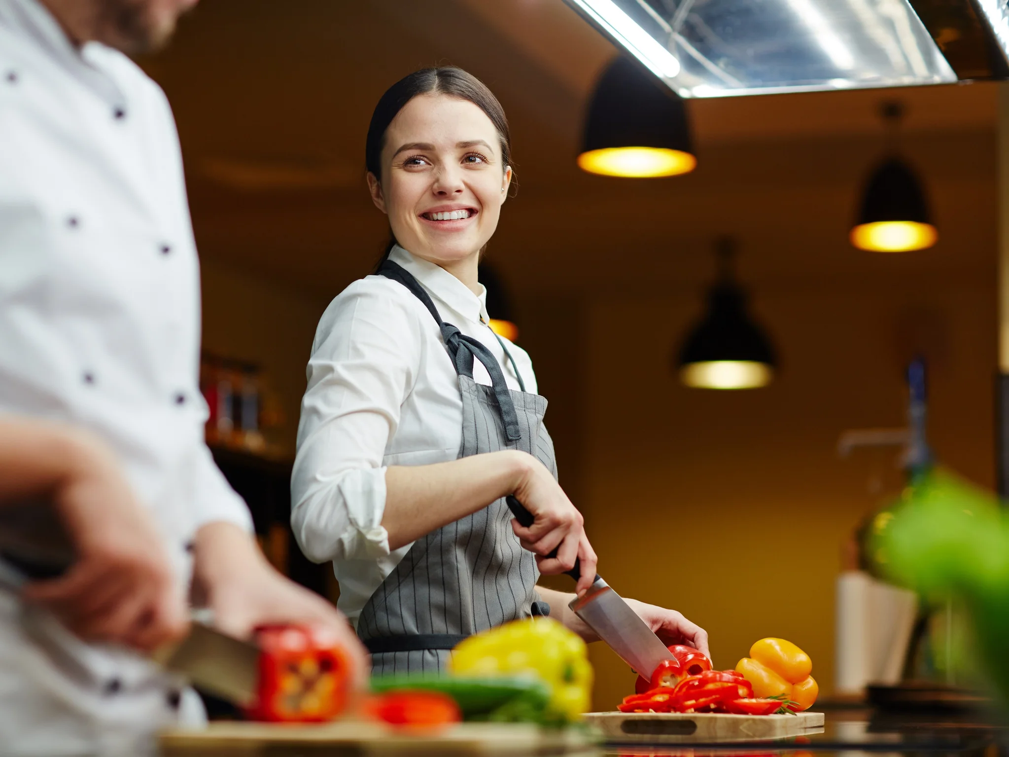 Smiling Commis Chef cutting vegetables
