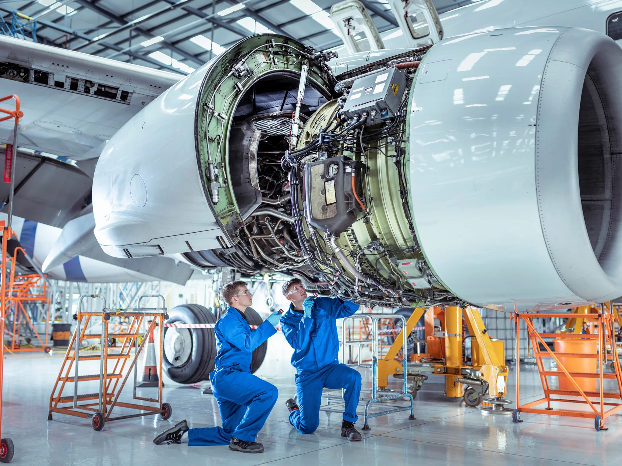 Two Aerospace engineers inspecting an exposed engine