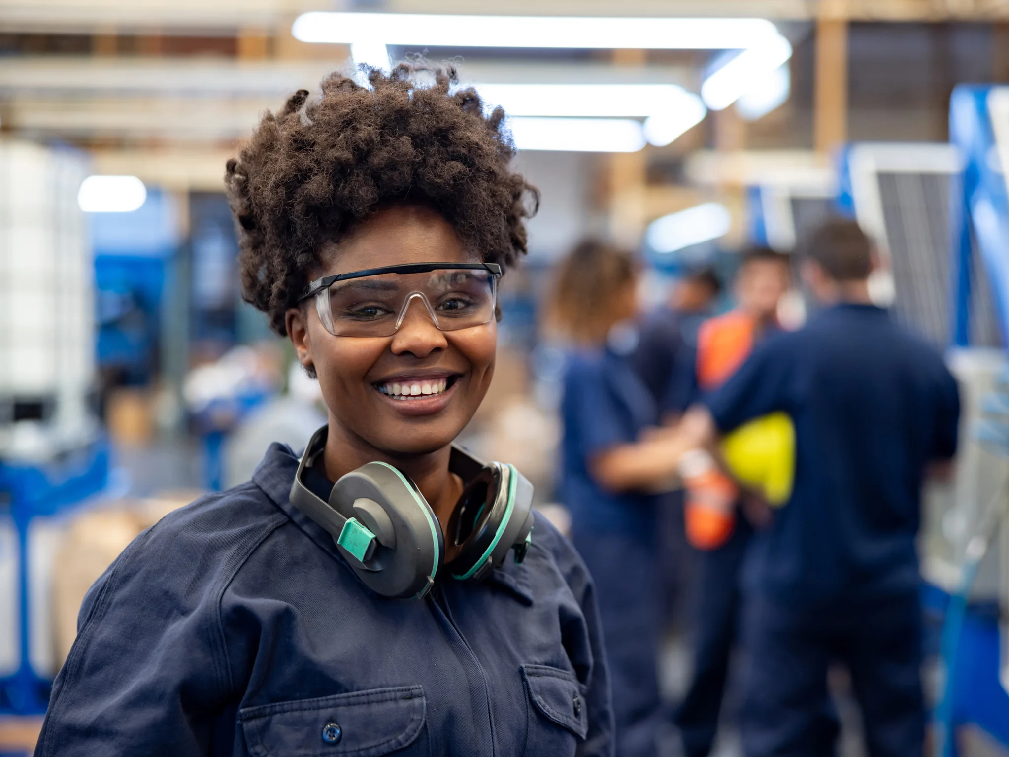 Smiling Engineer wearing safety goggles and ear defenders