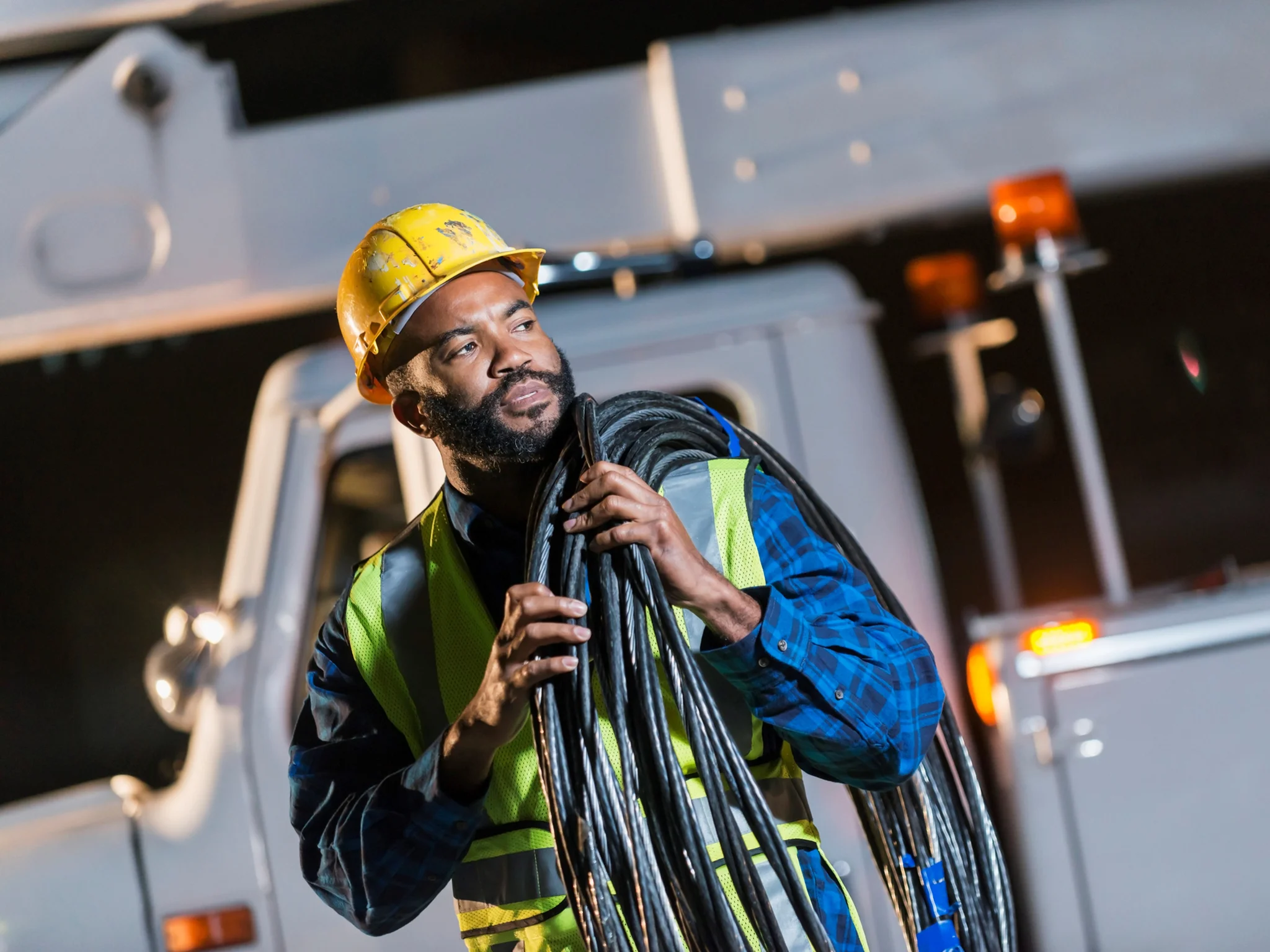 Engineer carrying bundled cables on a worksite