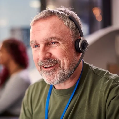 Healthcare and NHS image A Call Handler wearing a lanyard and talking on a headset