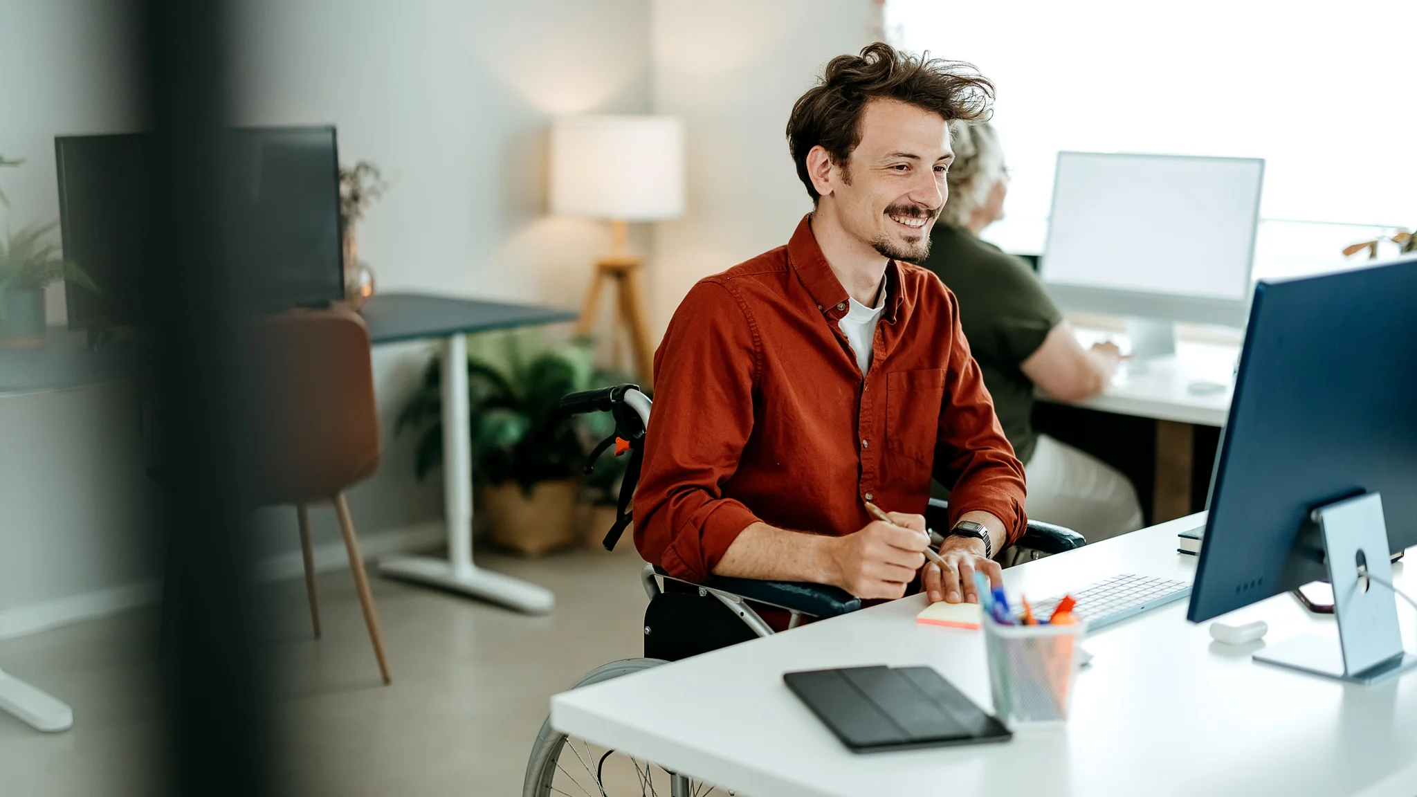 A smiling Demand Planning Manager making notes
