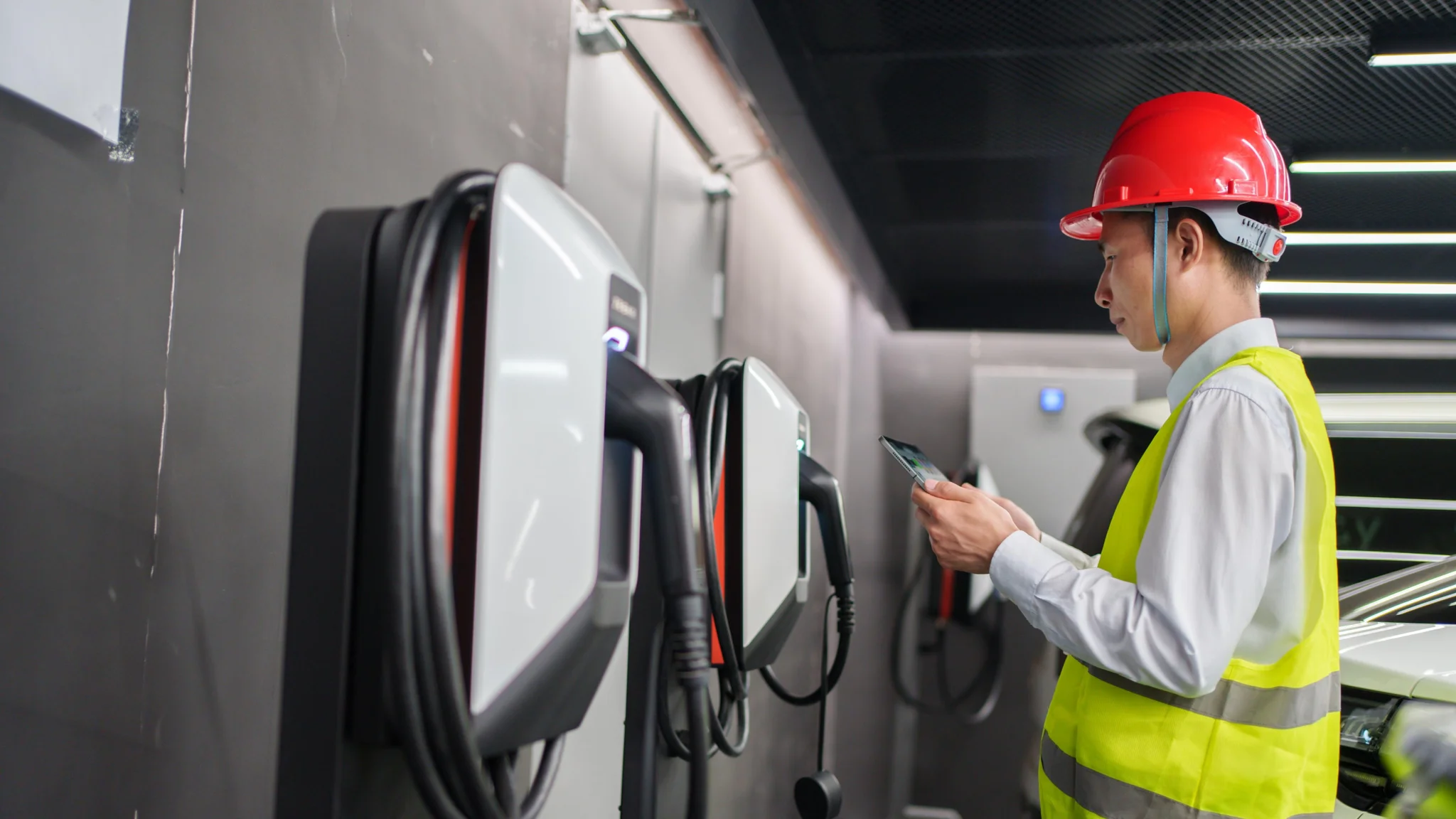 EV charge point operator inspecting charging station