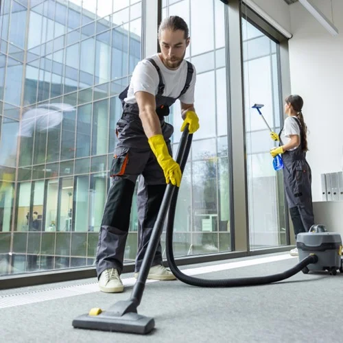 Facilities Management image A Cleaner vacuuming the floor in an office building