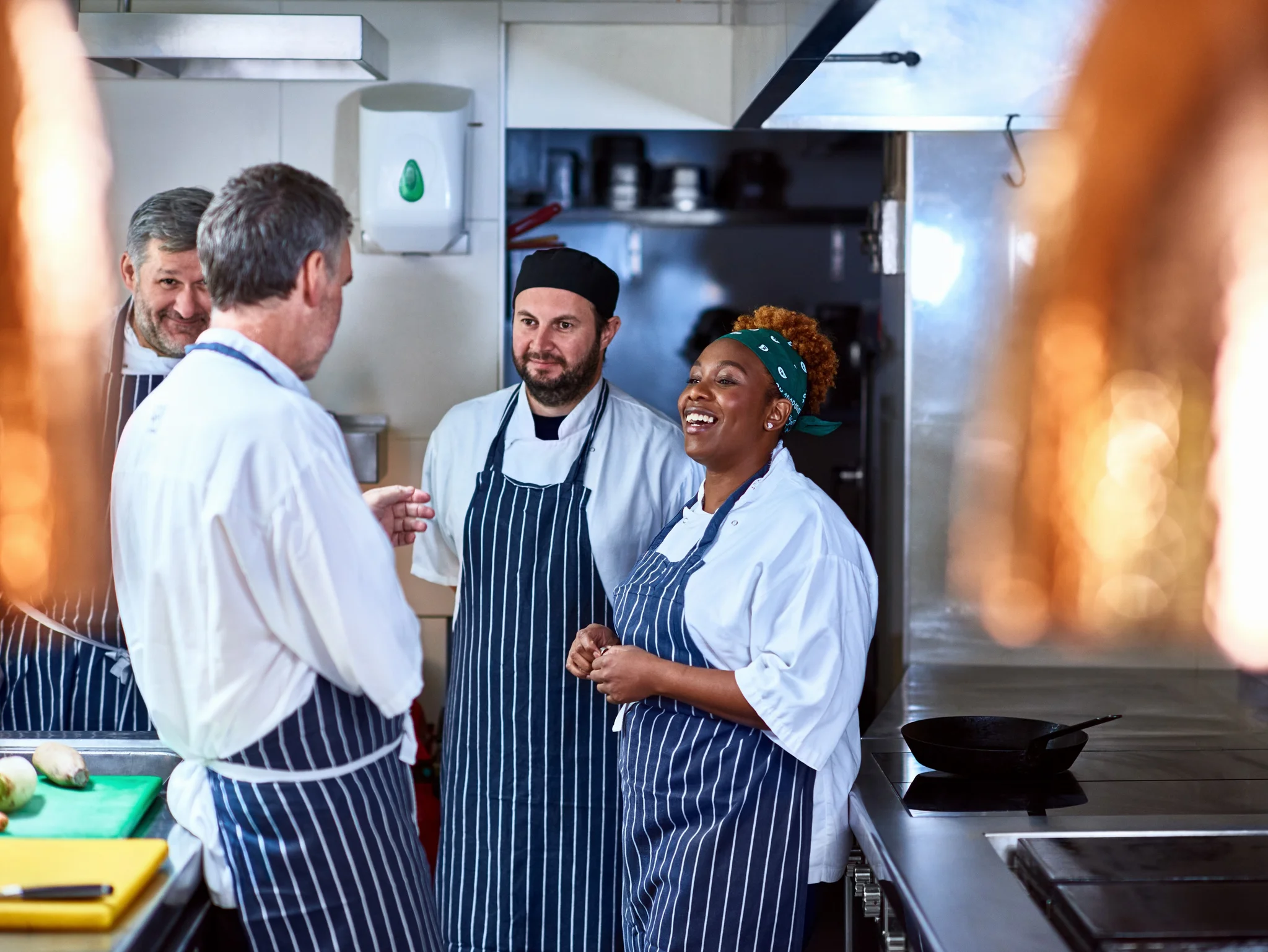 A Chef Manager speaking to a group of Chefs in a commercial kitchen