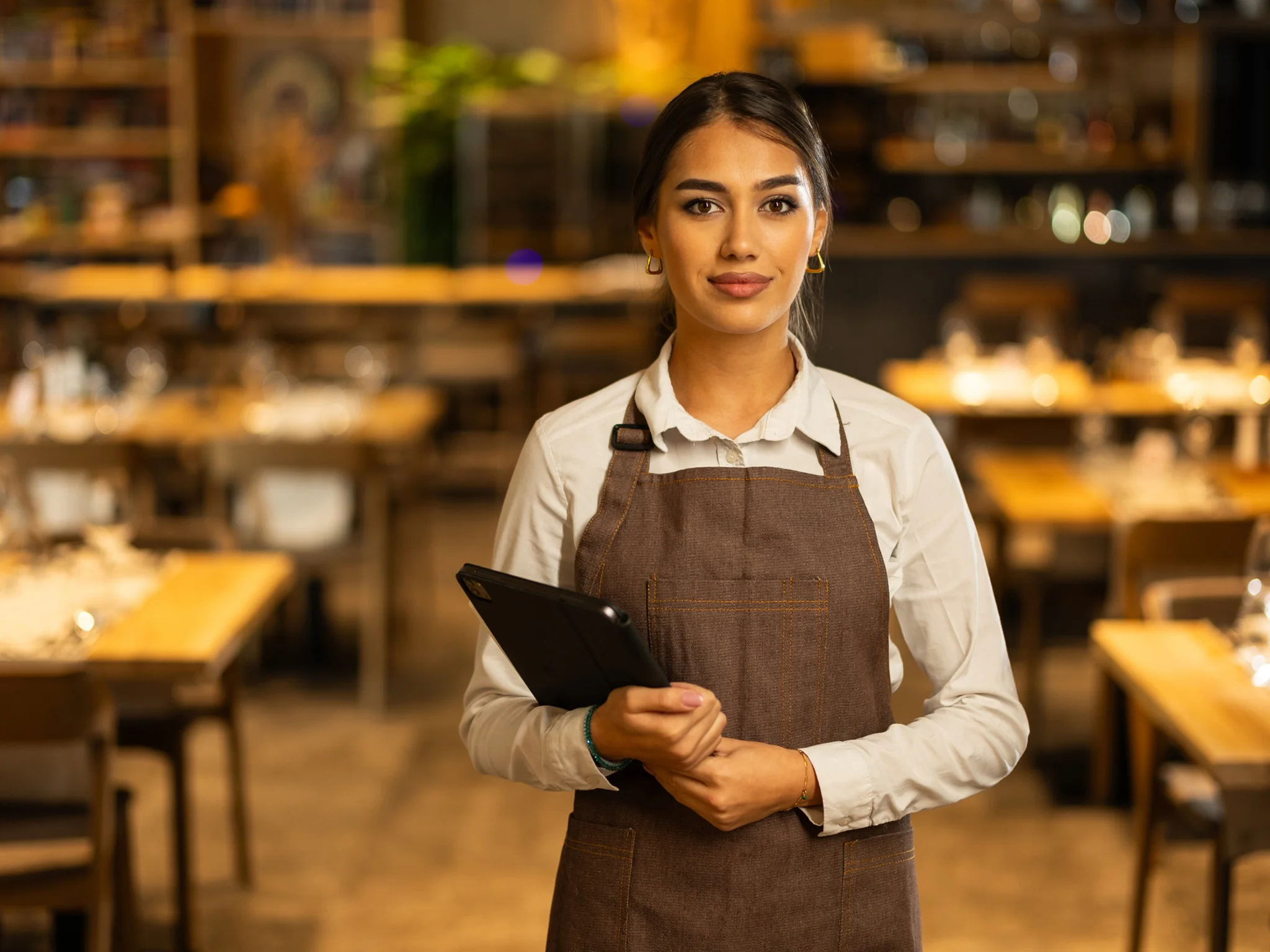 A Front of House staff member in a restaurant wearing a uniform