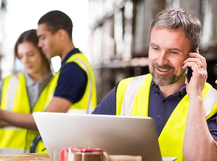 man in hi vis vest on phone