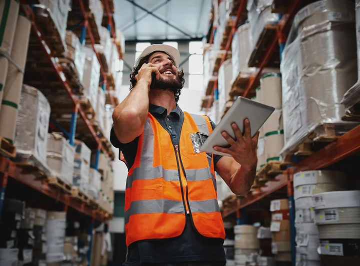 man in hi-vis on phone in warehouse