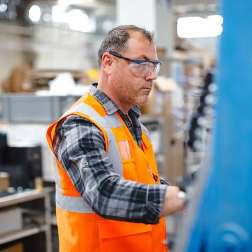 Case Studies preview image A Production Manager in an orange hi vis vest wearing safety glasses
