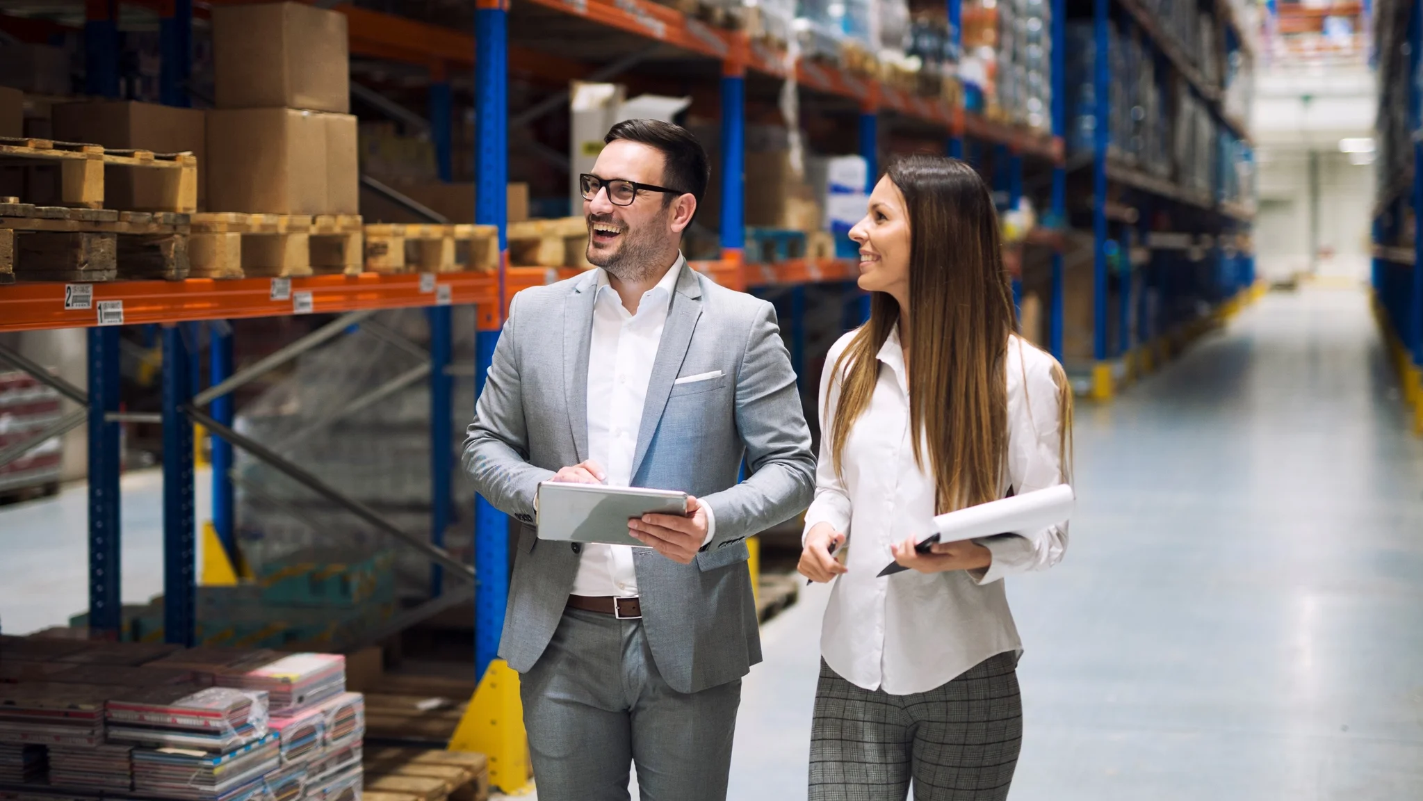 A Head of Supply Chain and Head of Operations walking round a warehouse with clipboards.