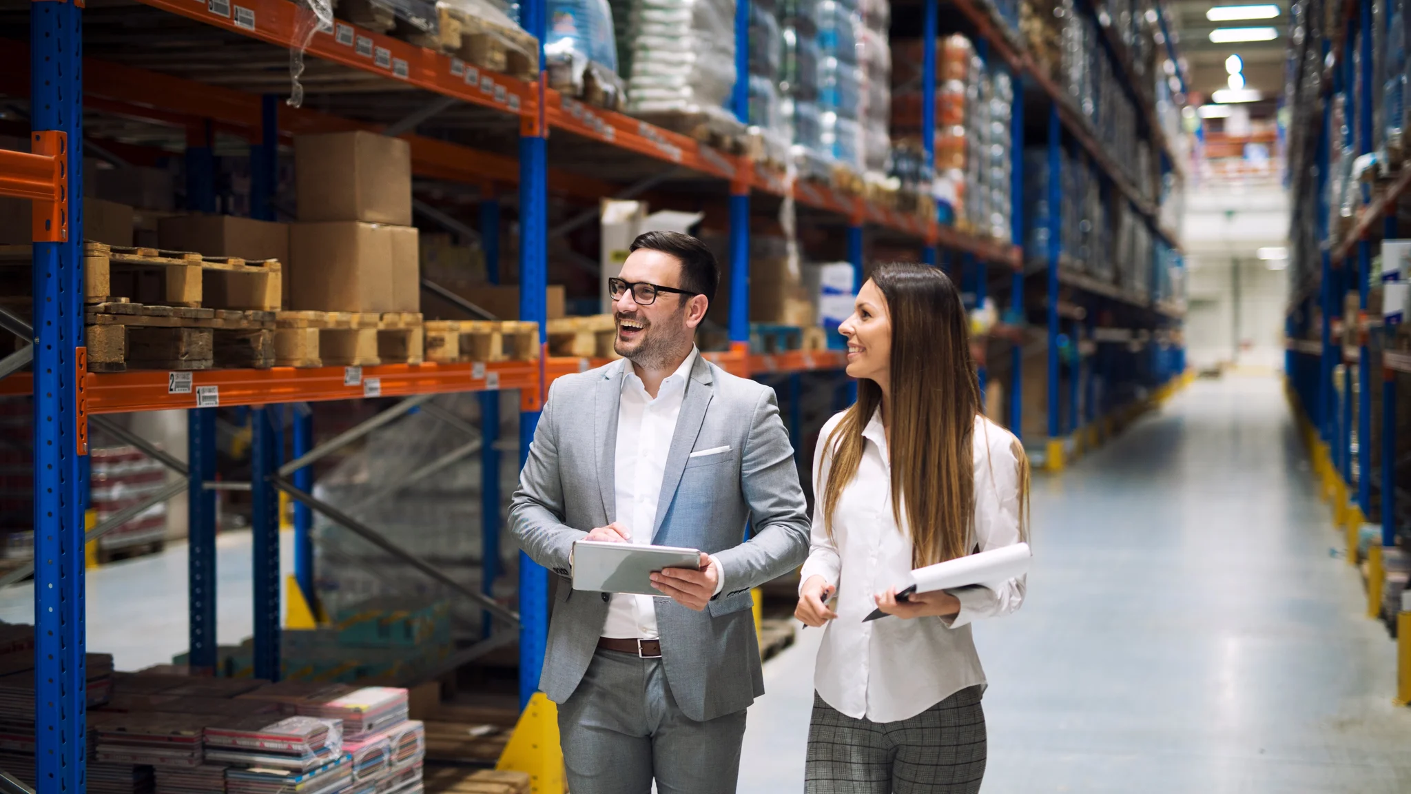 Logistics managers reviewing inventory inside a large warehouse