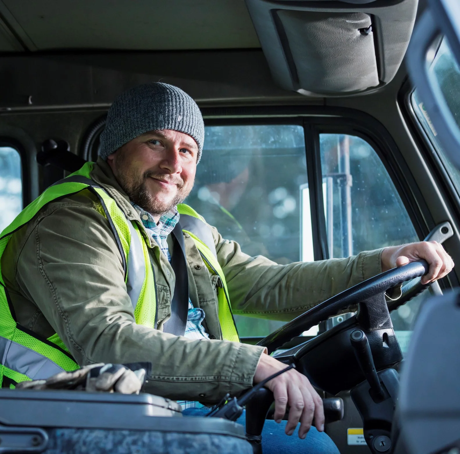 Smiling driver in a vehicle wearing a hi-vis