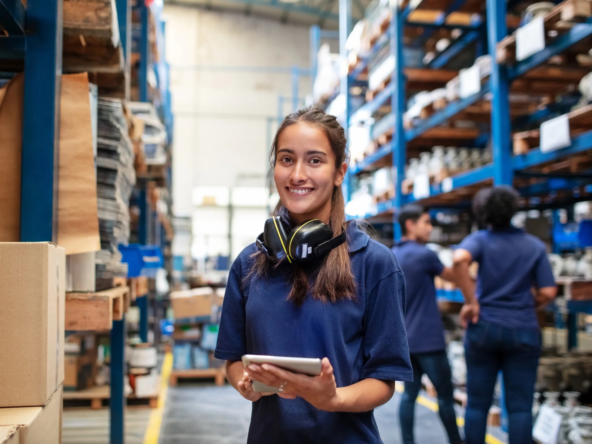 Smiling warehouse worker with a tablet in their hands