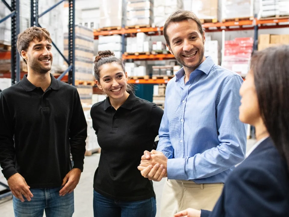 Four logistics leaders holding a meeting inside a warehouse