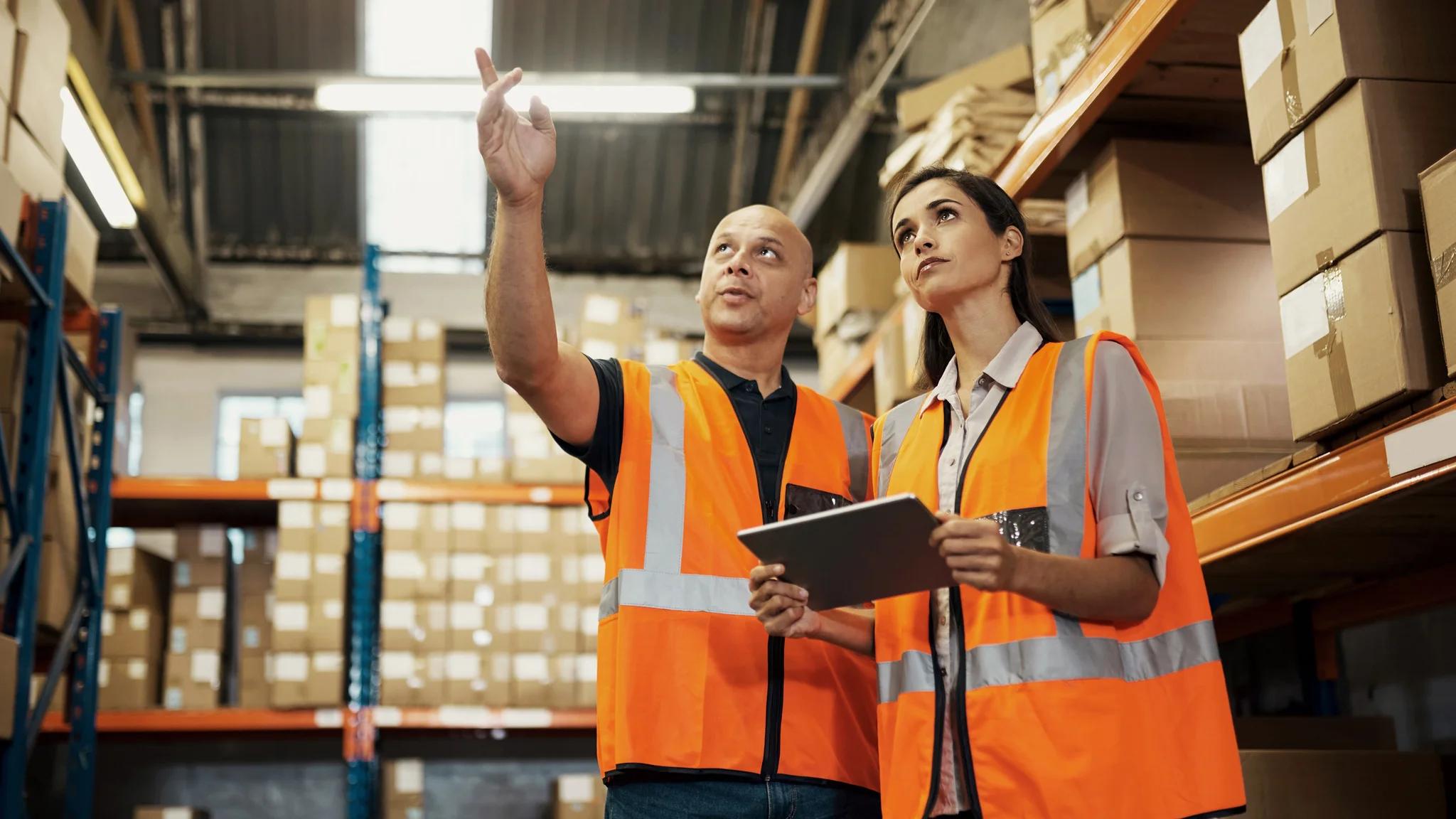 Two warehouse workers discussing inventory