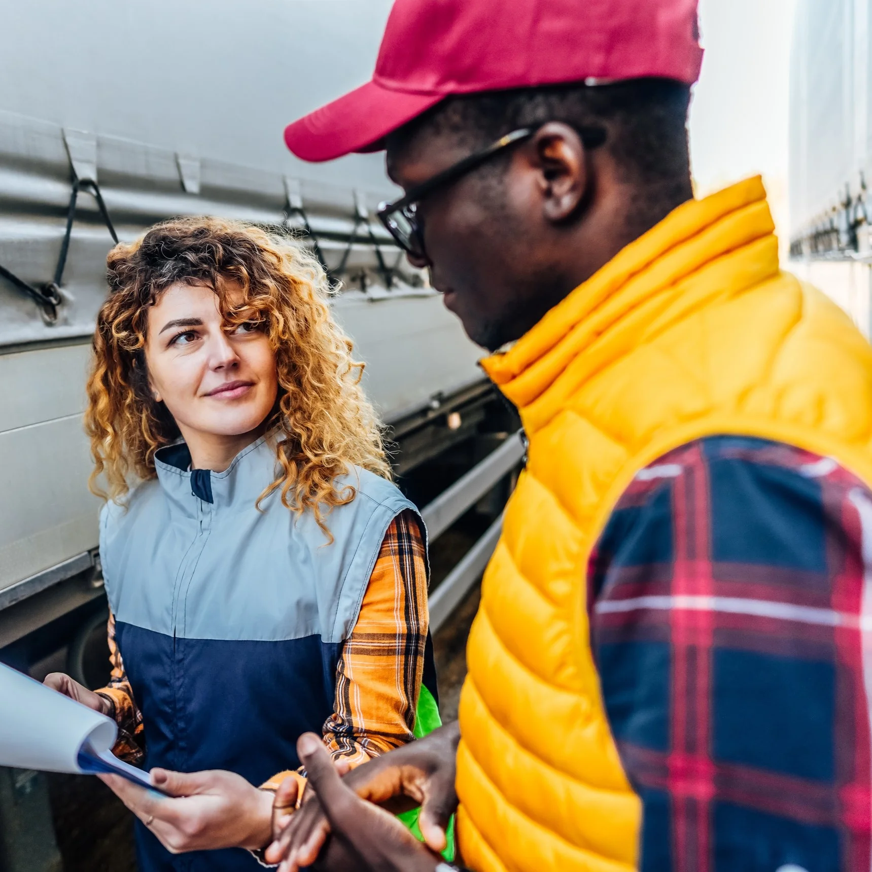 Haulage workers in discussion next to a delivery vehicle