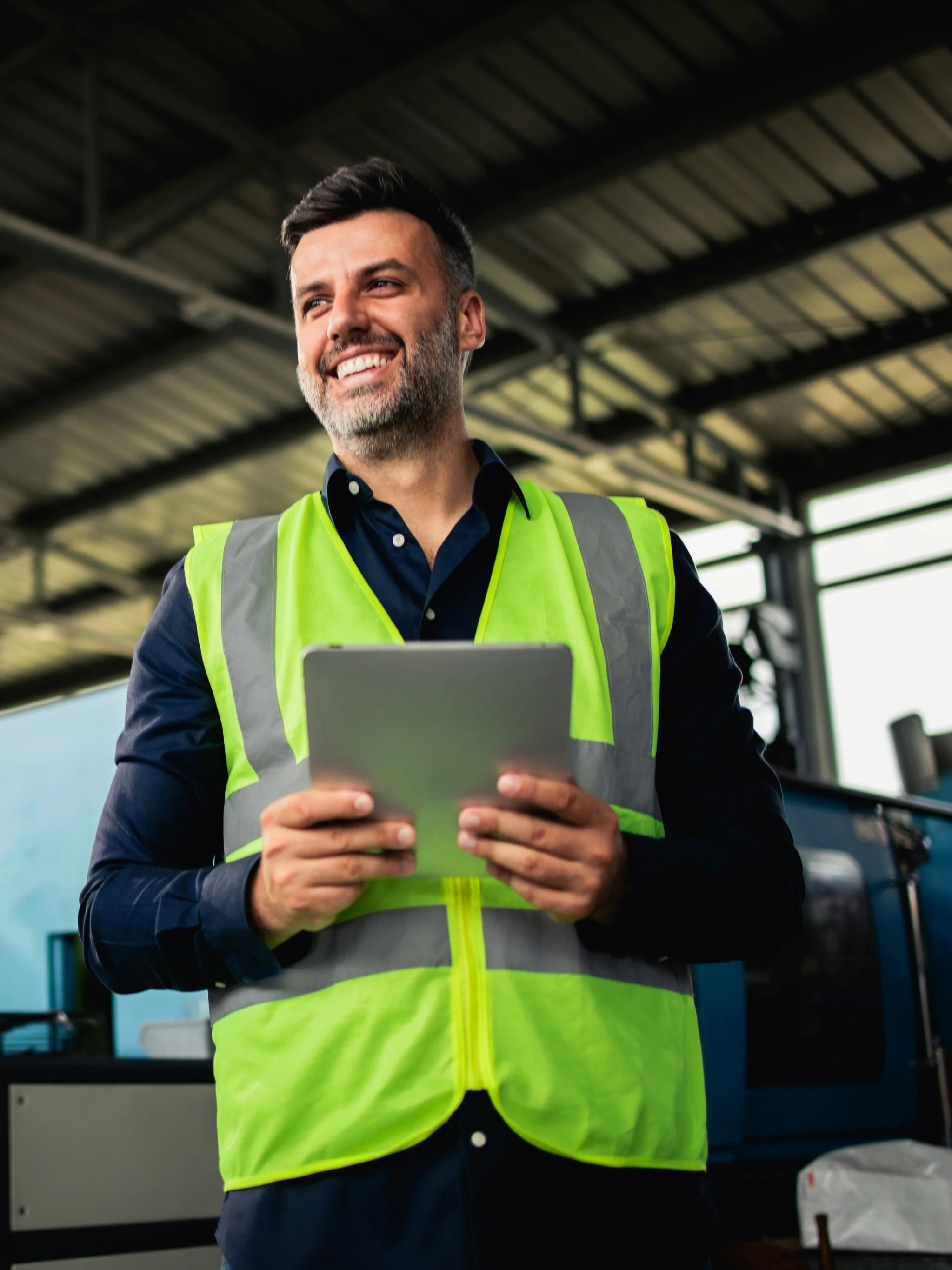 A smiling logistics worker holding a tablet