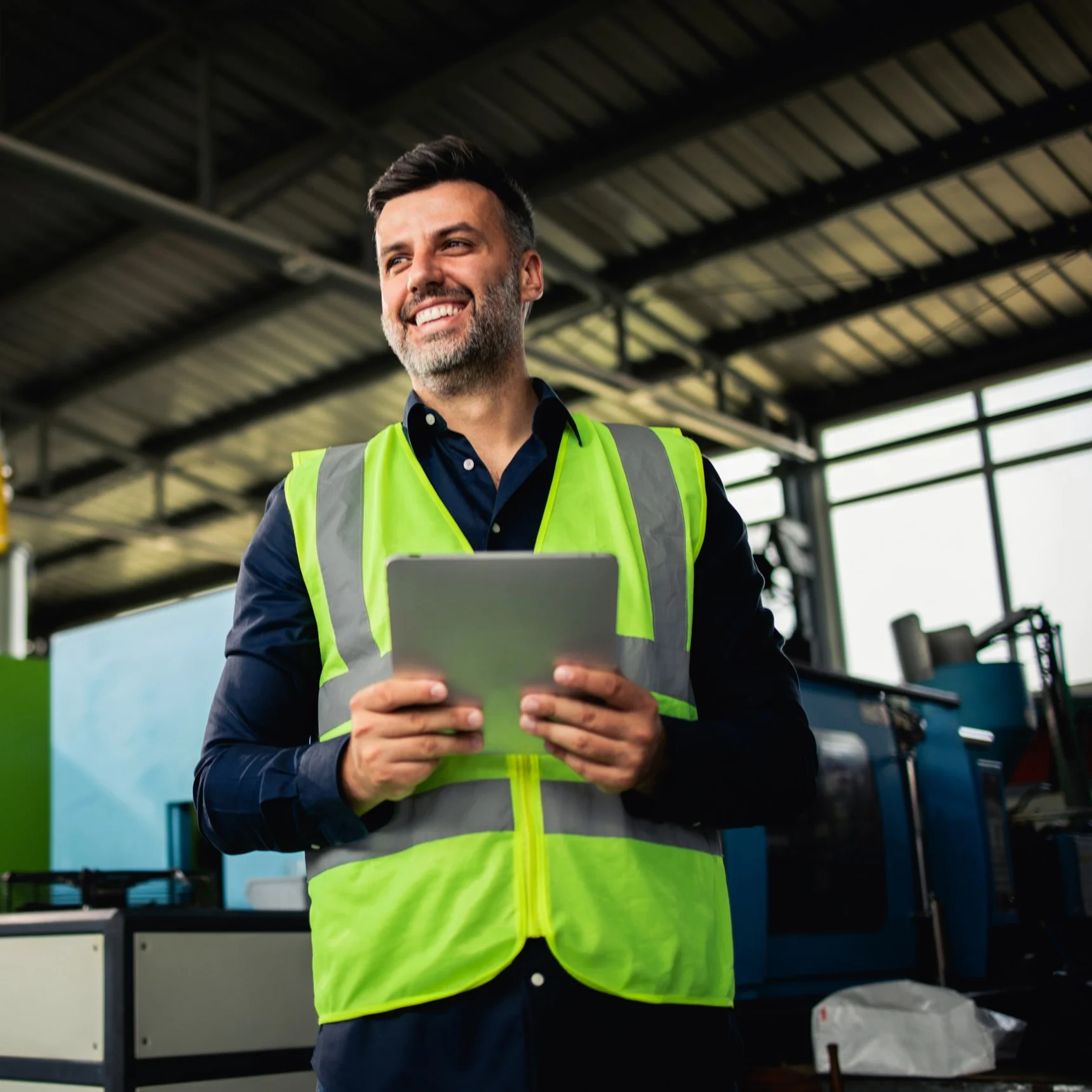 Logistics worker wearing high-visibility vest holding a tablet