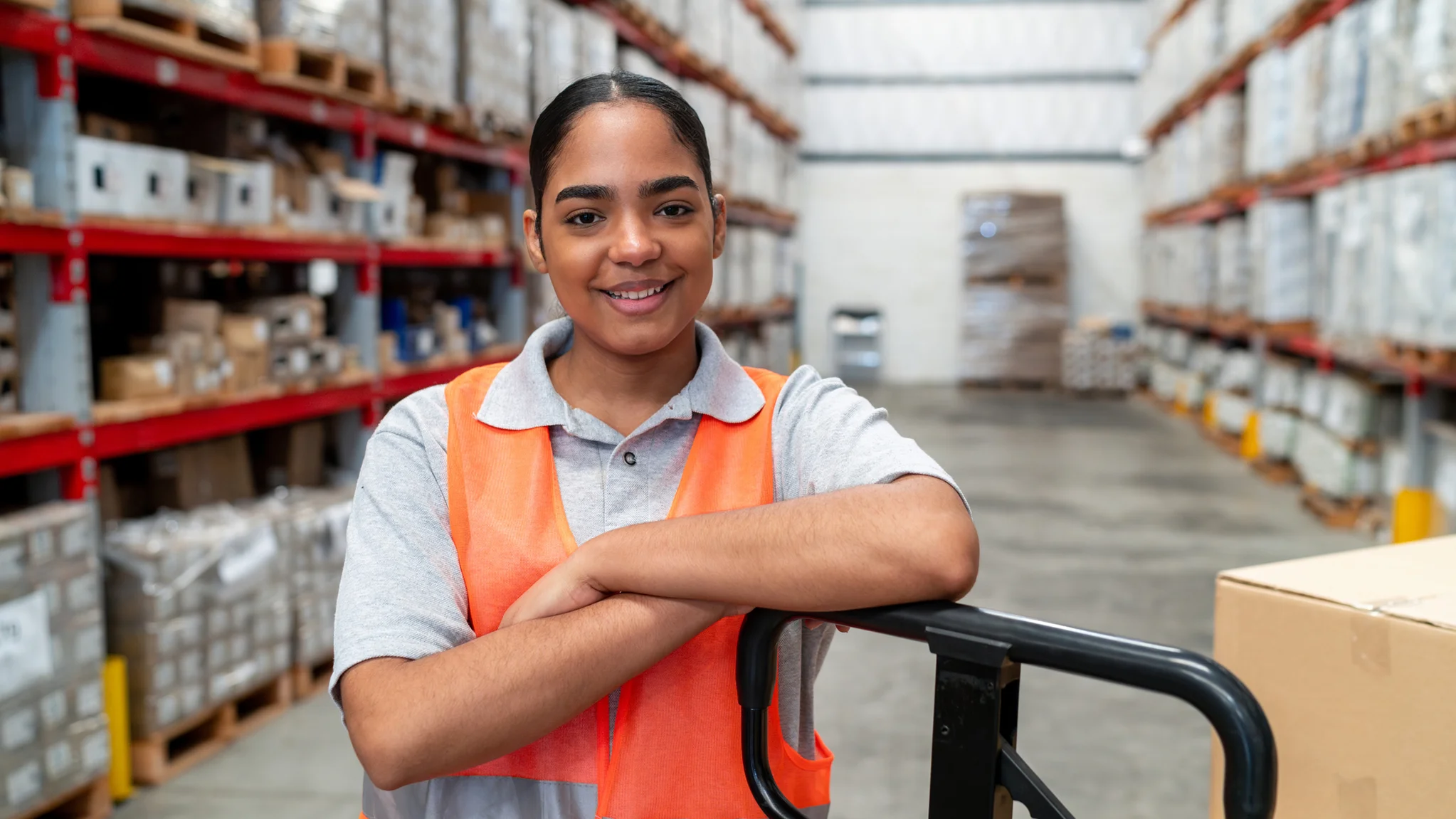 Smiling Warehouse worker leaning on a pallet jack