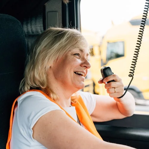Fulfilment+ image HGV driver in orange hi vis vest talking on a radio
