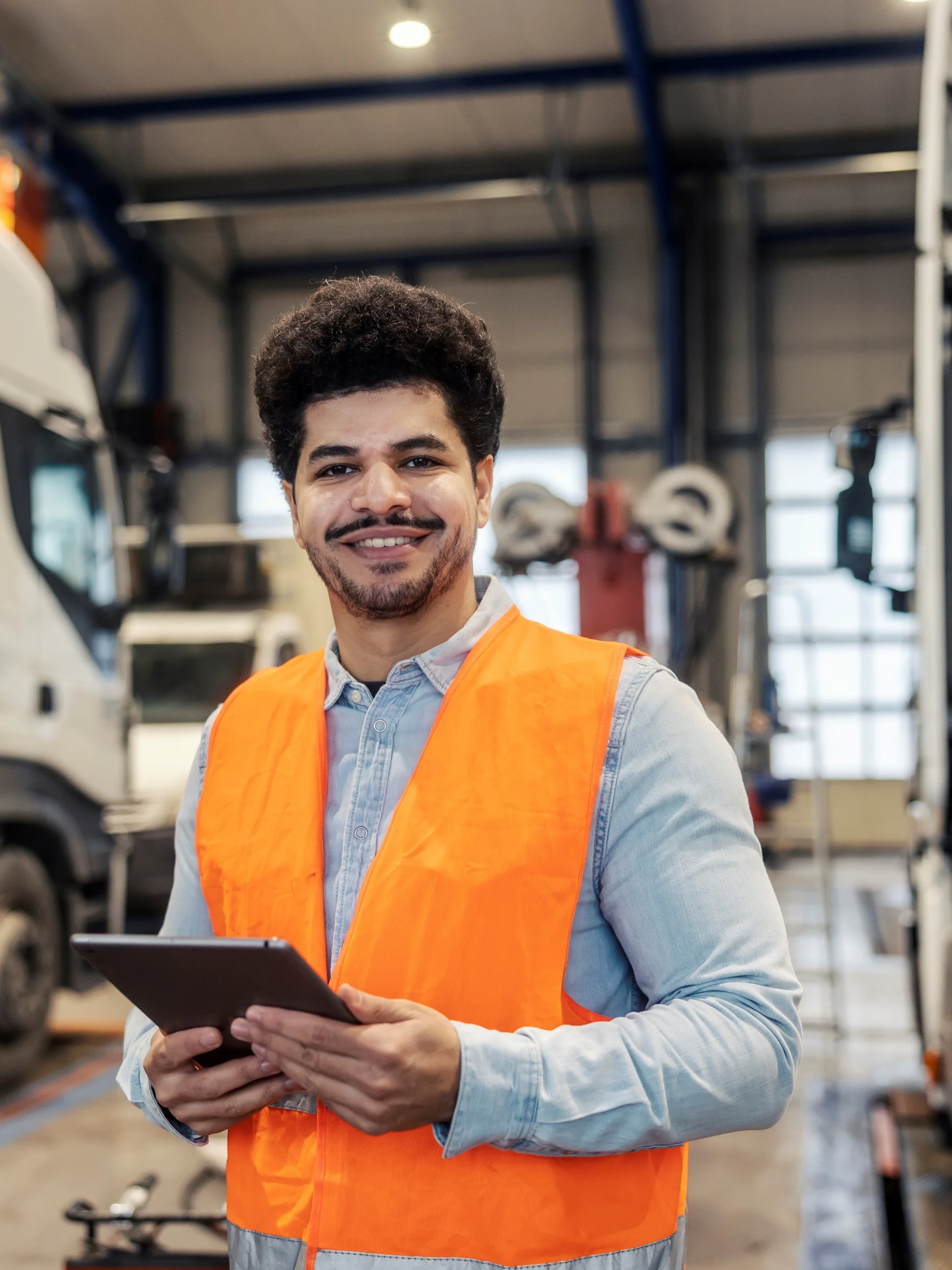 Smiling logistics worker holding a tablet