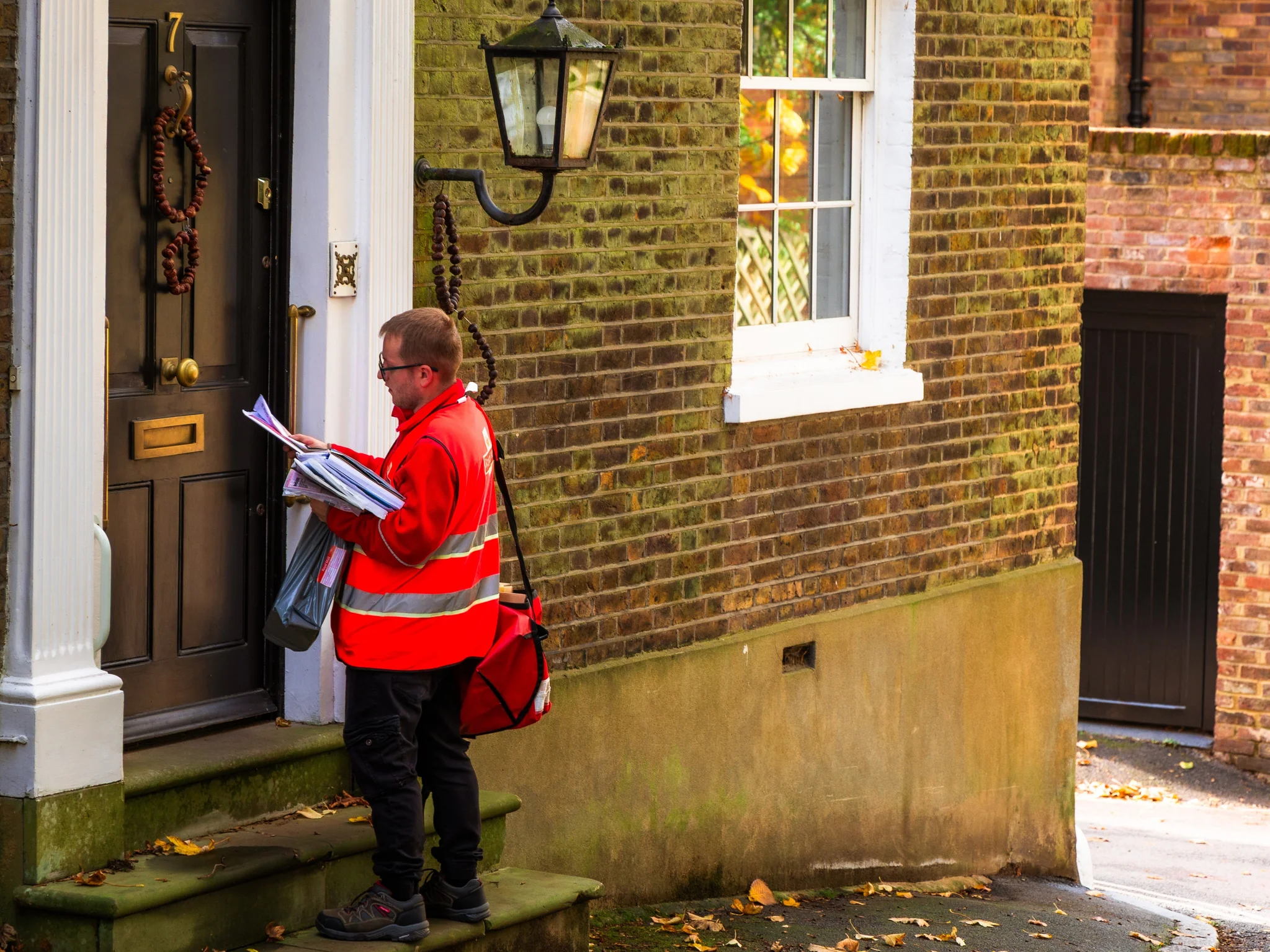 Royal Mail postman delivering mail