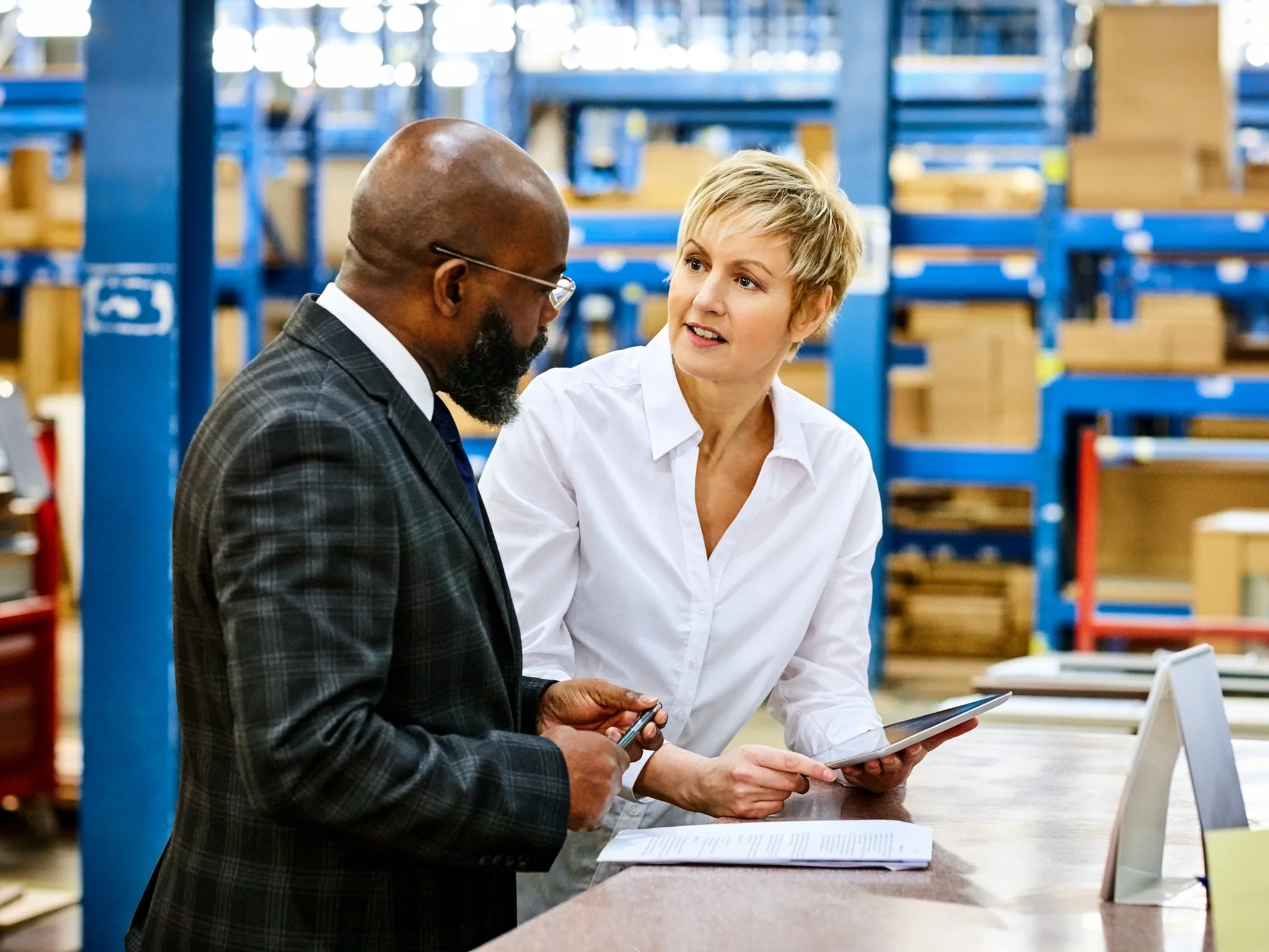 Two professionals in discussion in a warehouse