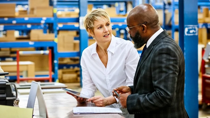 Two Senior Logistics leaders in a warehouse talking