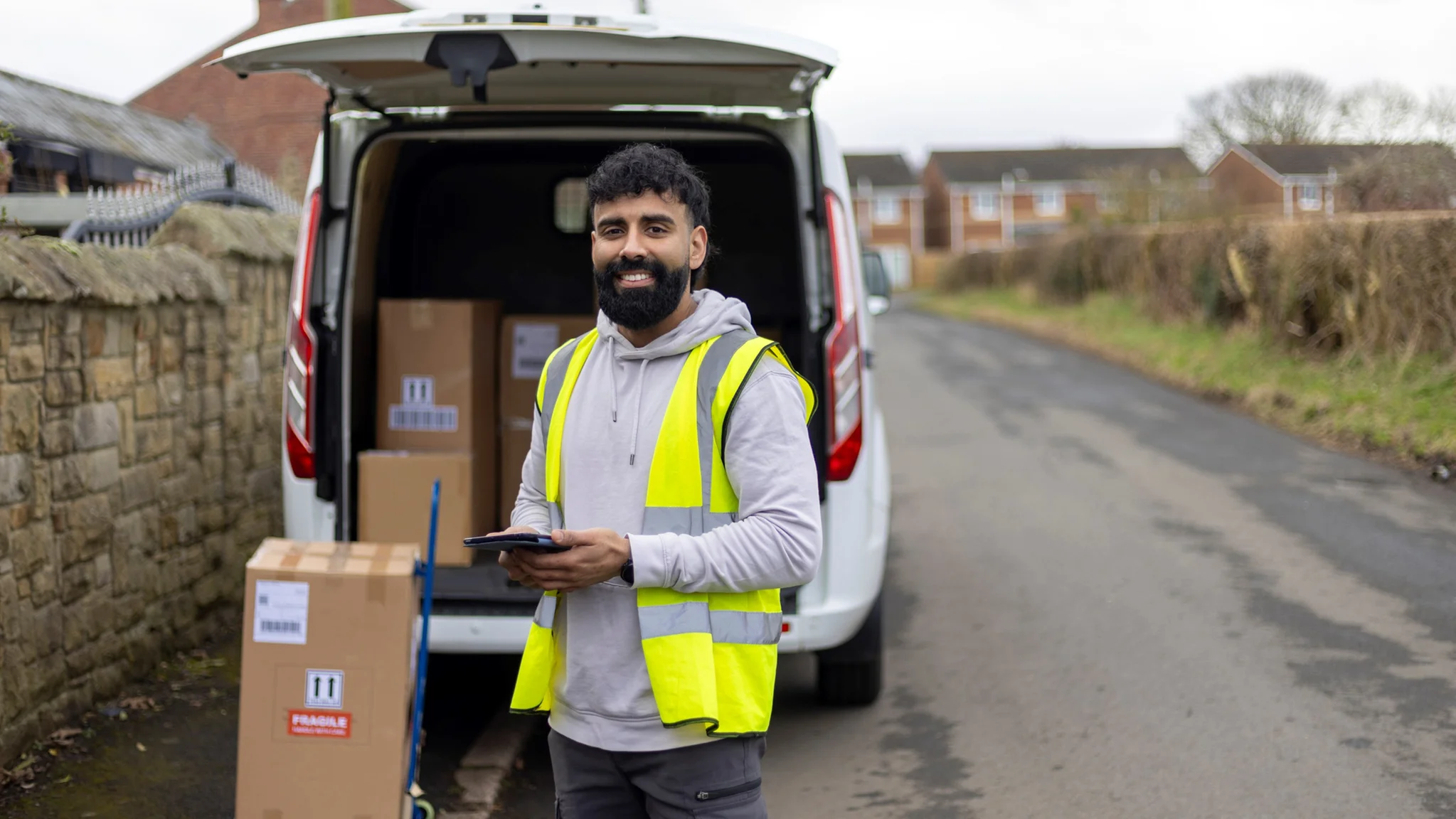 Van driver stood outside their van with parcels