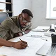 man writing at desk