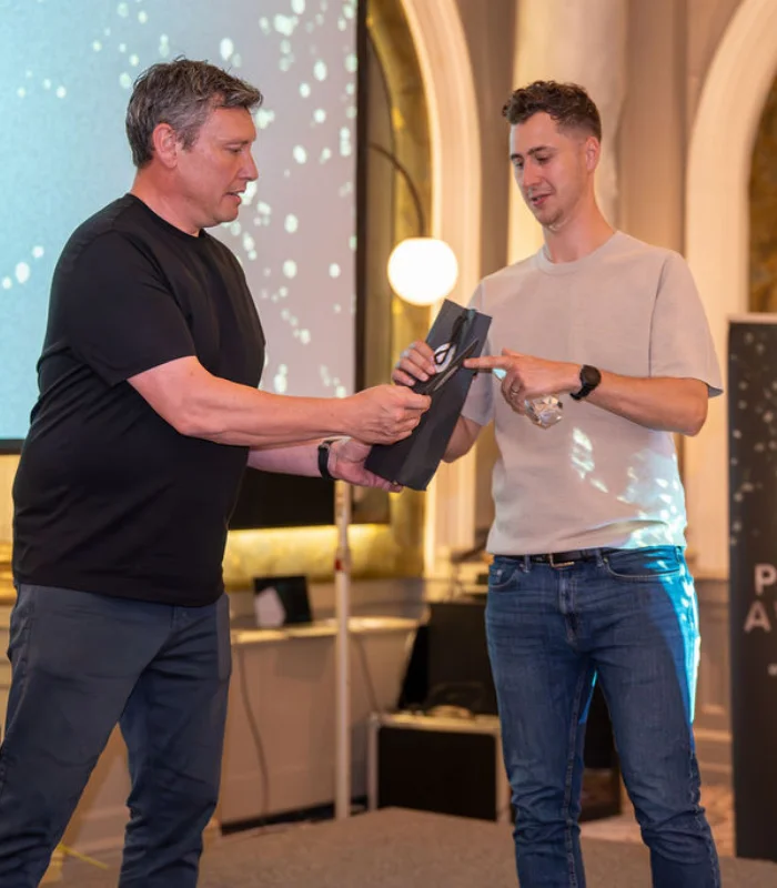 Man receiving recruitment award from another man