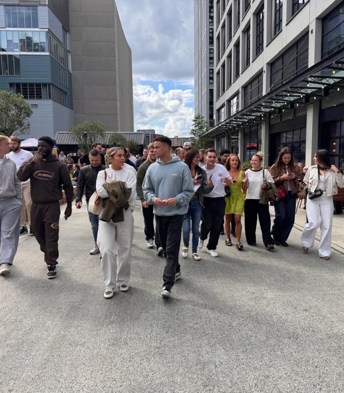 group of men and women walking through manchester 