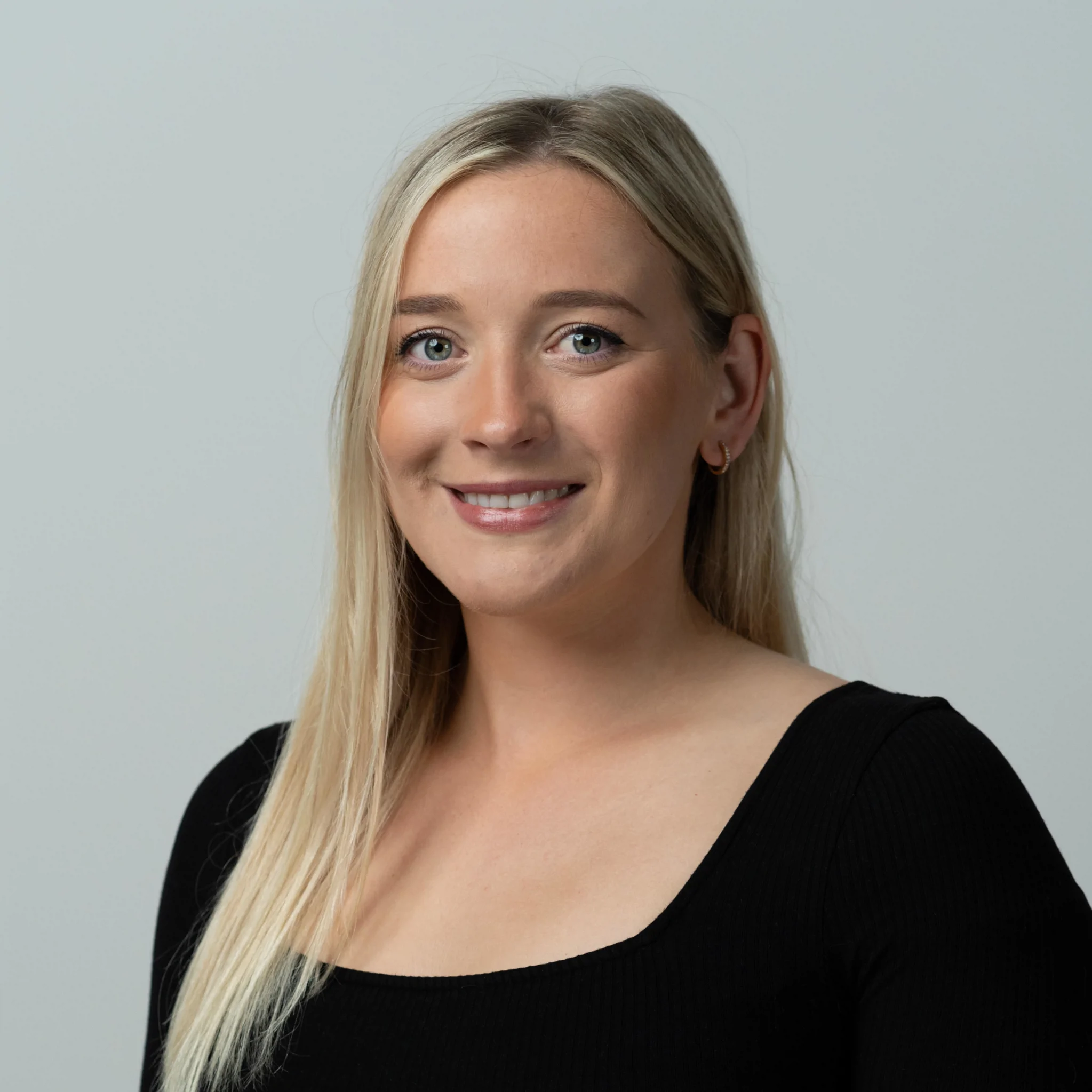 Abby Child, Advanced Trainer, Woman With Blonde Hair Smiling With Black Top On