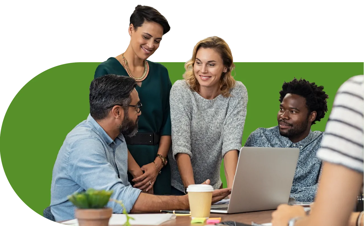 Team of people sitting at standing at a desk around a computer having a meeting