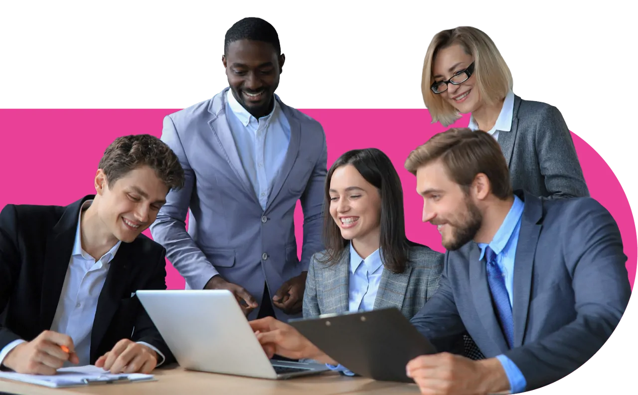 Colleagues smiling, sat and standing at a desk around a laptop