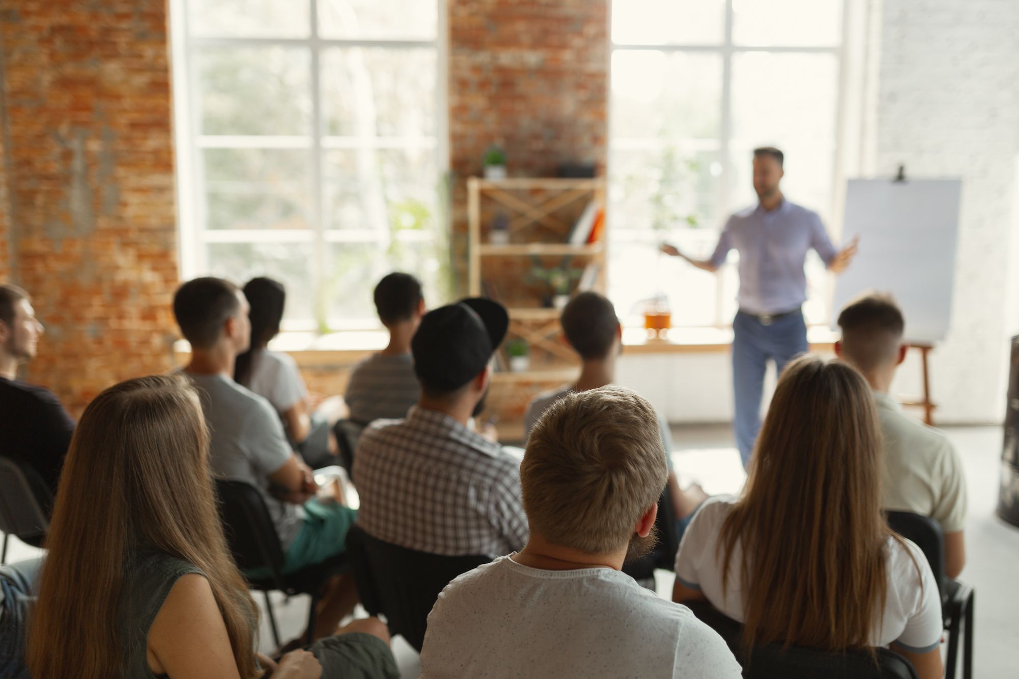 A room of people listening intently to speaker presenting. 