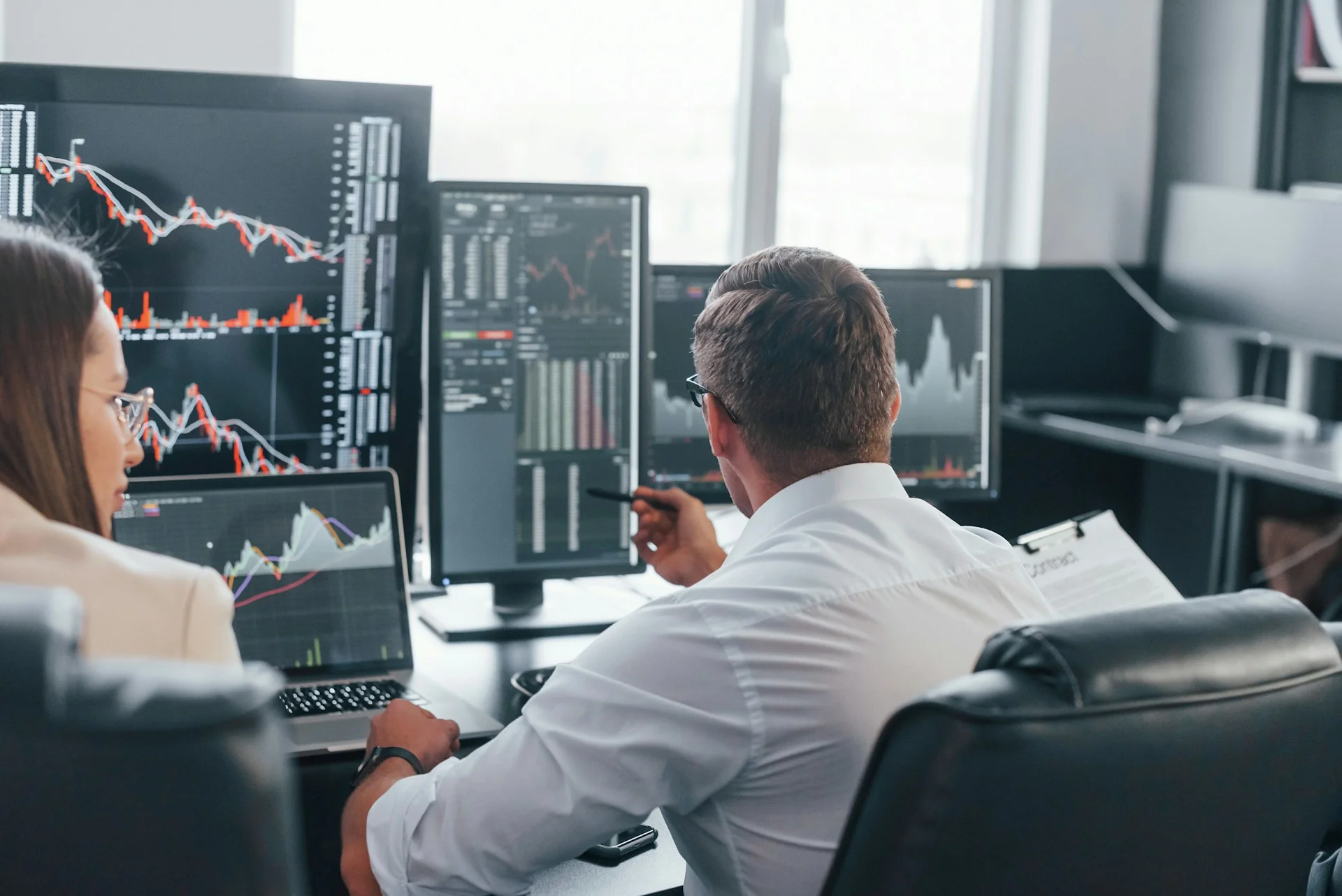 team-of-stockbrokers-works-in-modern-office-with-many-display-screens-