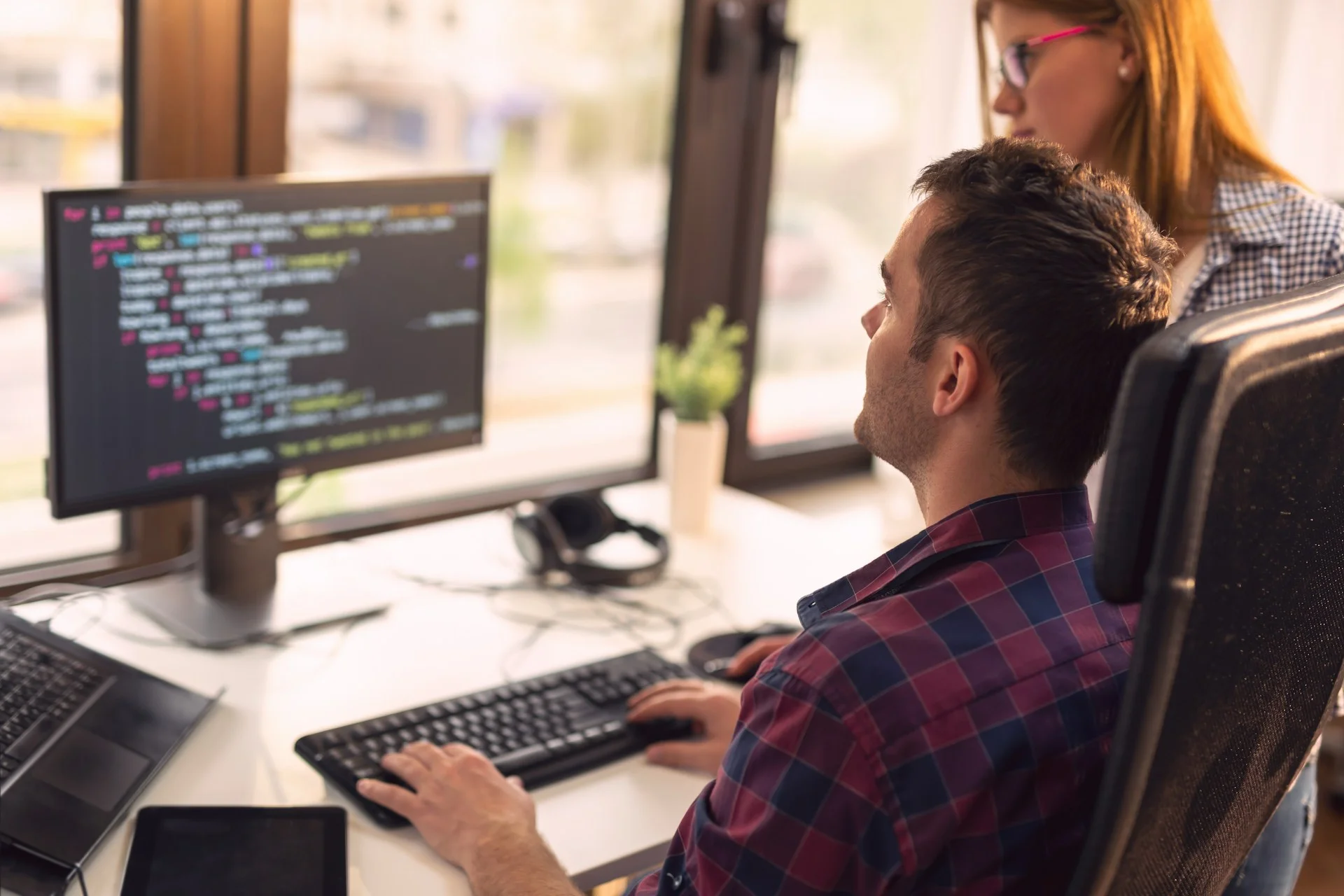 two-senior-developers-working-in-a-software-developing-company-office-focus-on-the-man-