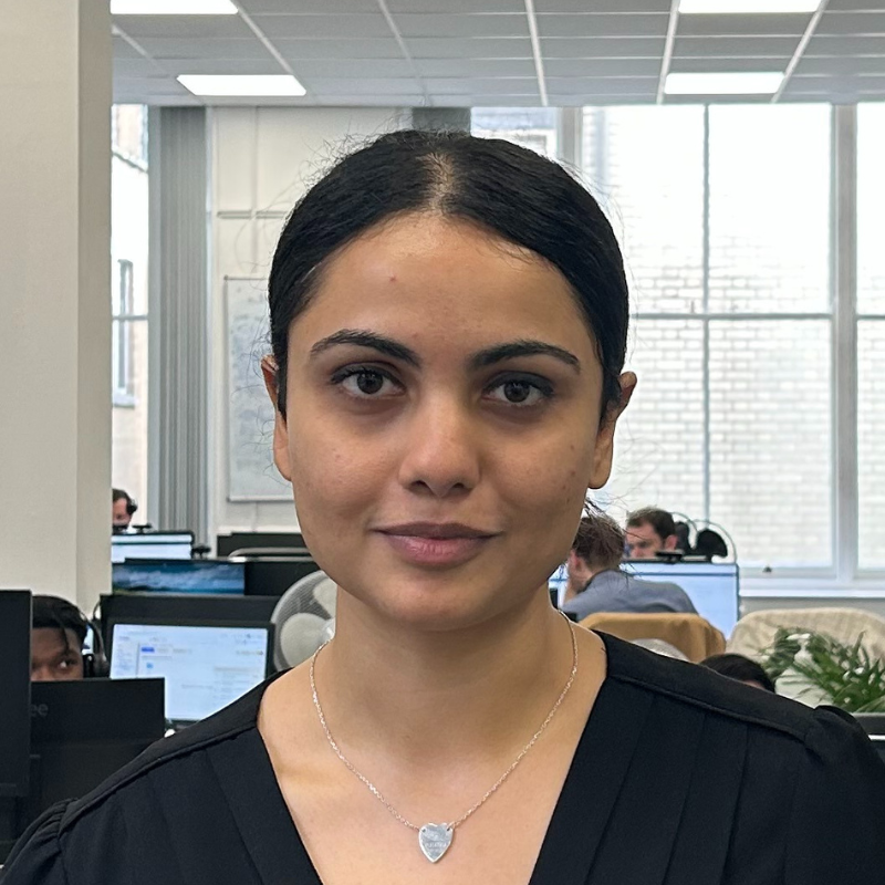 A young woman in an office smiling at the camera. She is Arshee Dey, Team Leader.