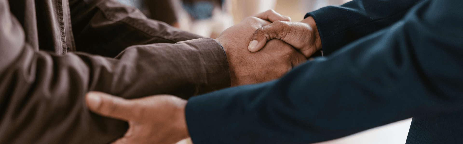 A close-up shot of two people in smart business attire shaking hands.