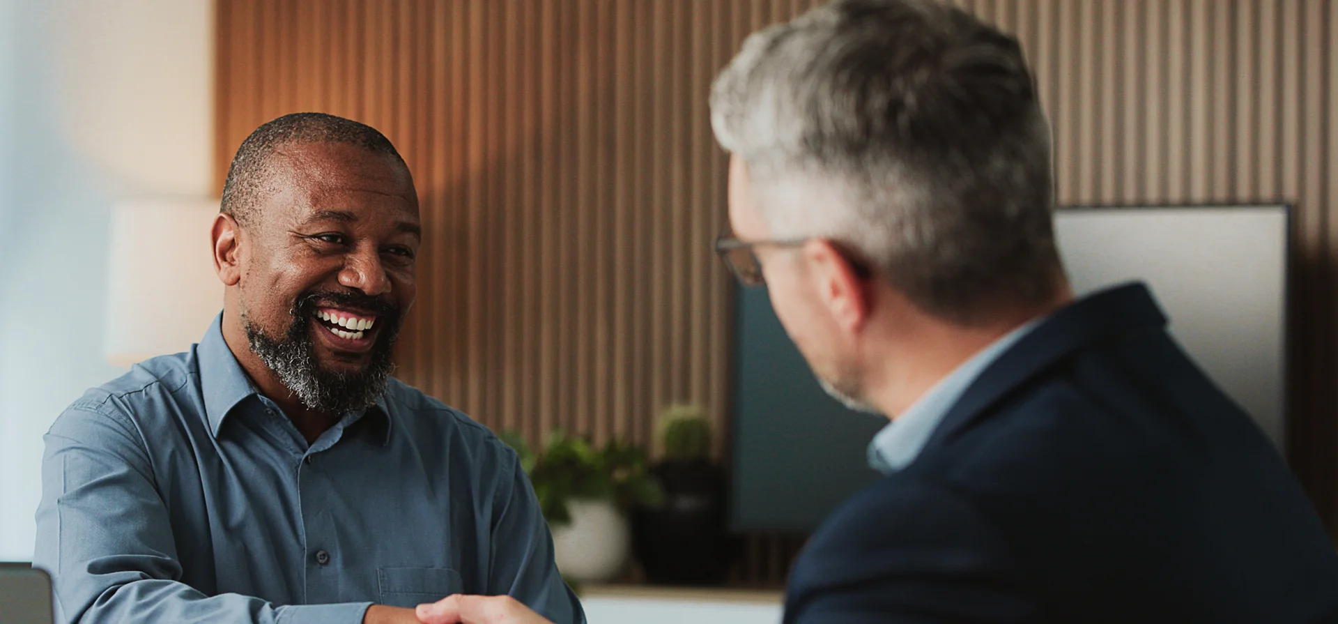 men shaking hands smiling