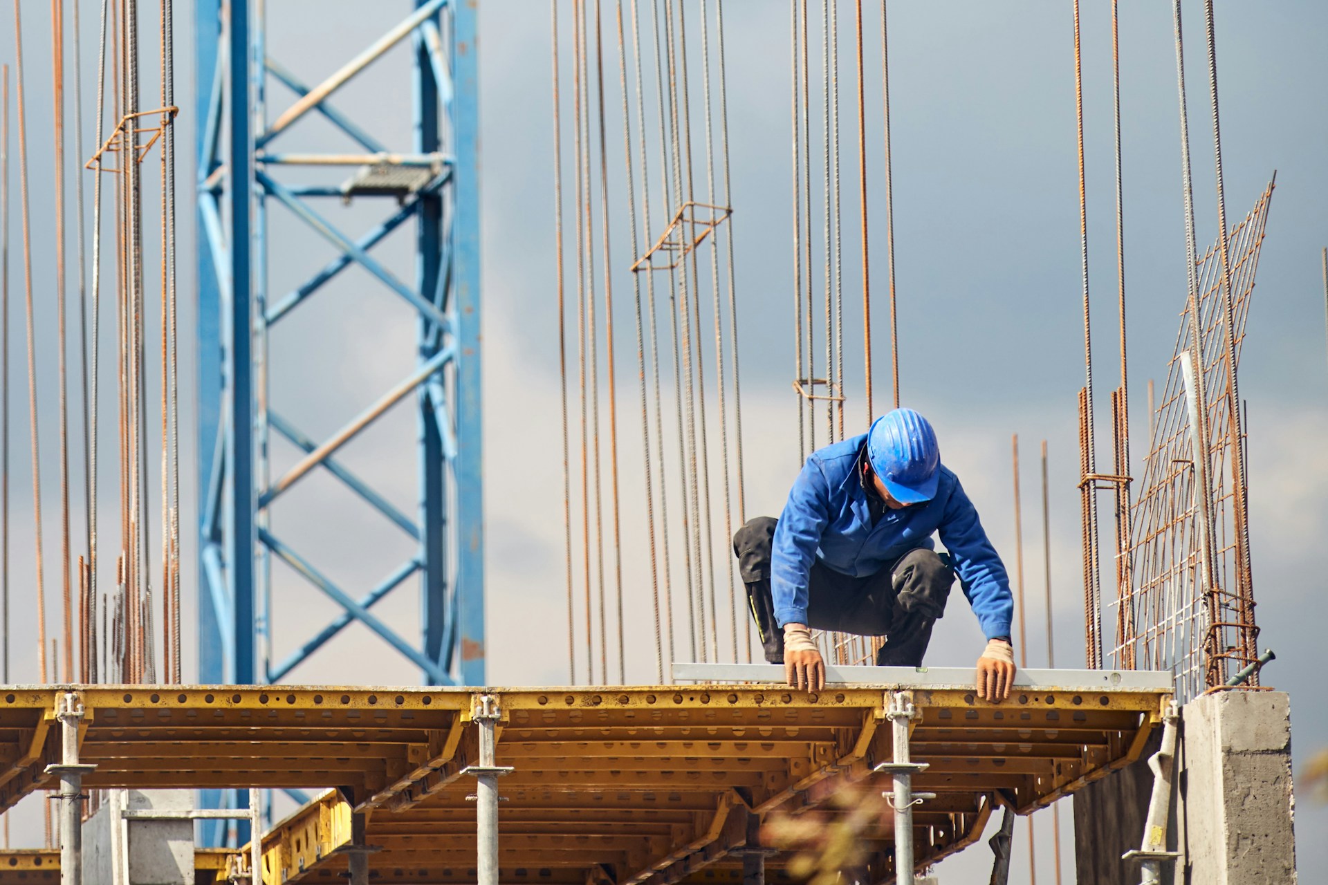 real-construction-worker-working-on-a-high-building-and-leveling-floor-for-cementing-