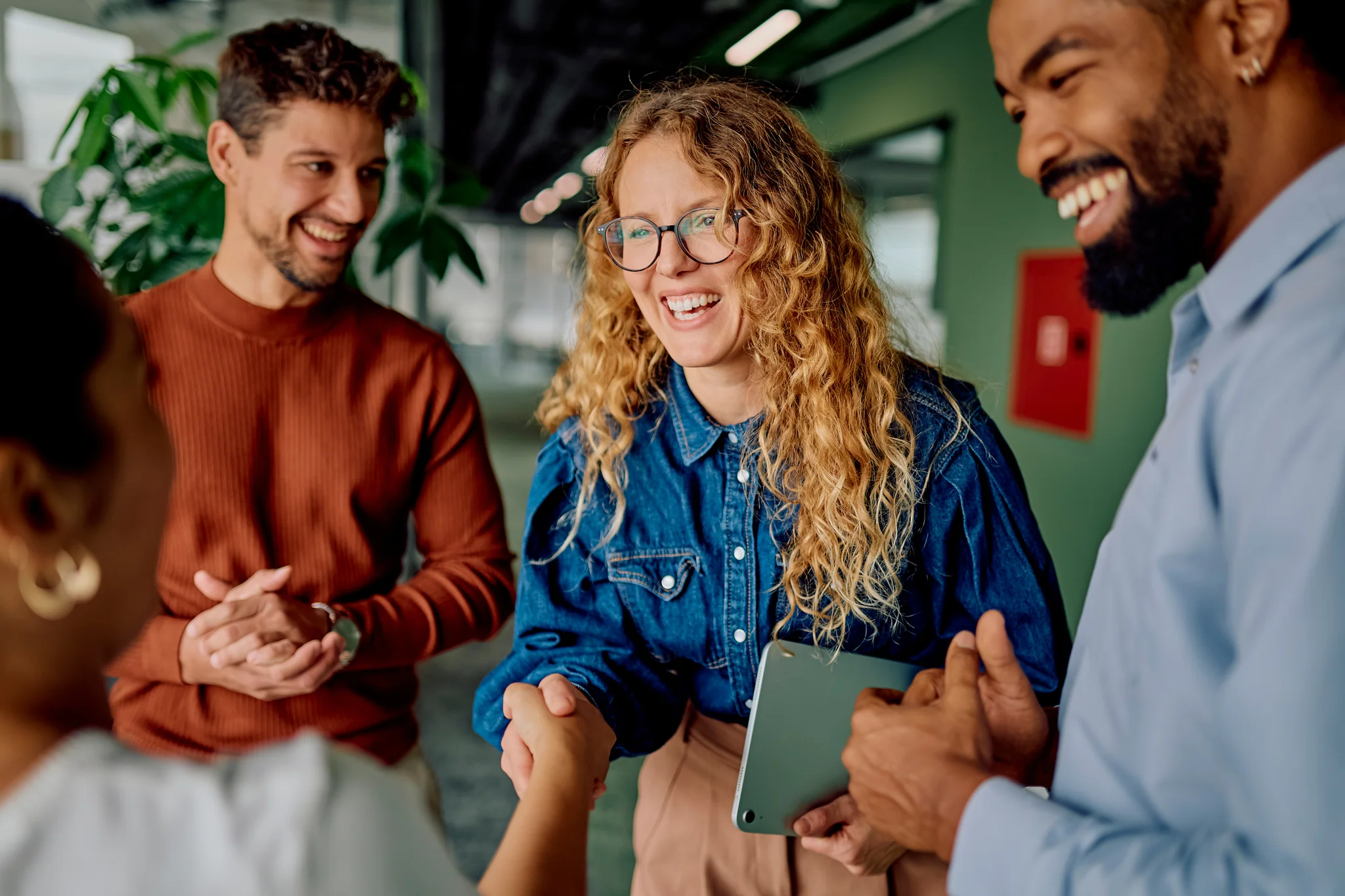 Business professionals shaking hands, celebrating collaboration and building a strong partnership in a modern office meeting