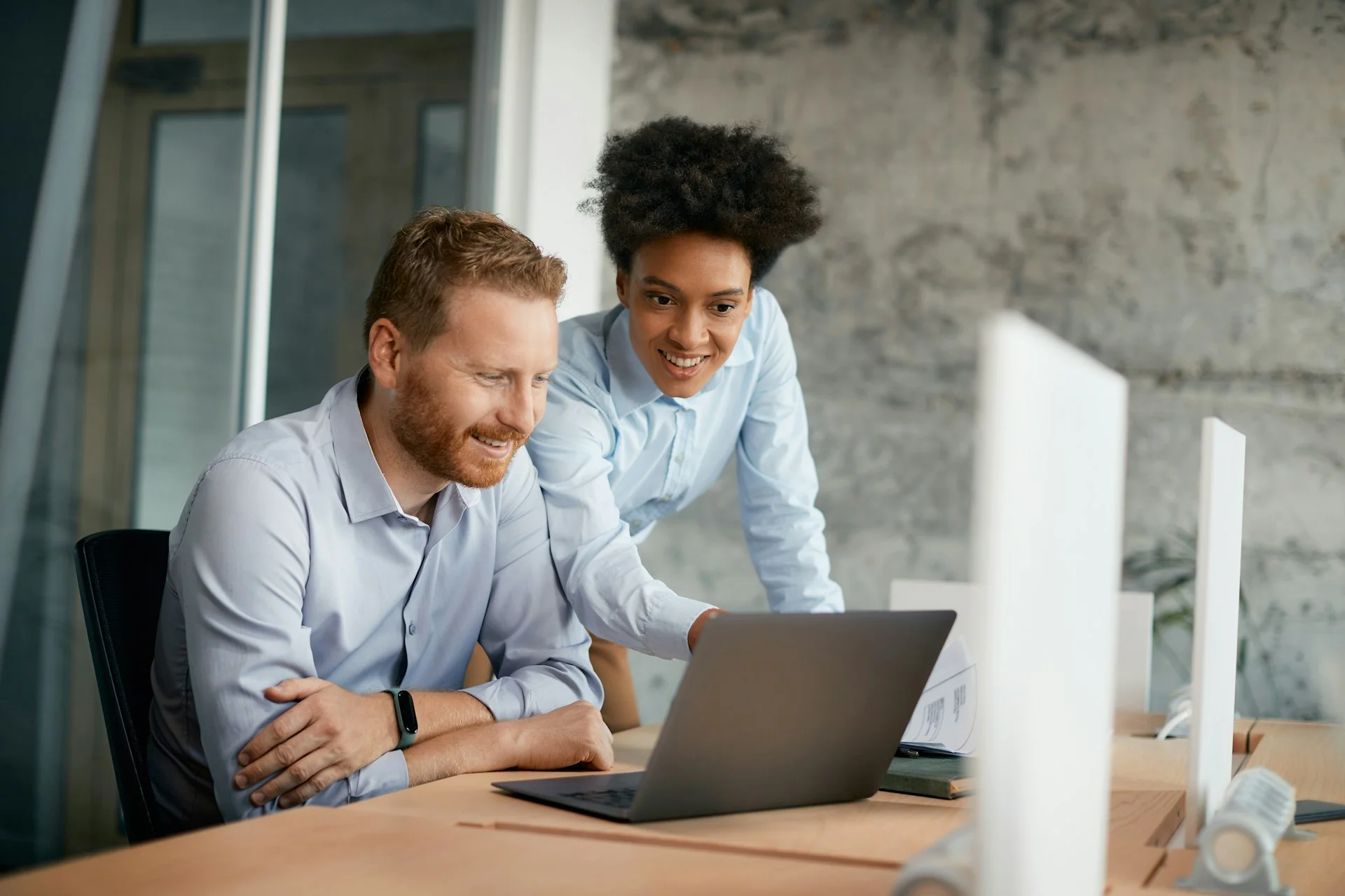 Two-people-in-a-meeting-looking-at-a-laptop