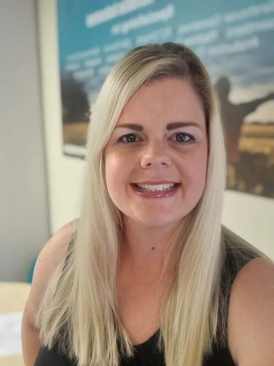 Woman with blonde hair smiling for headshot phot