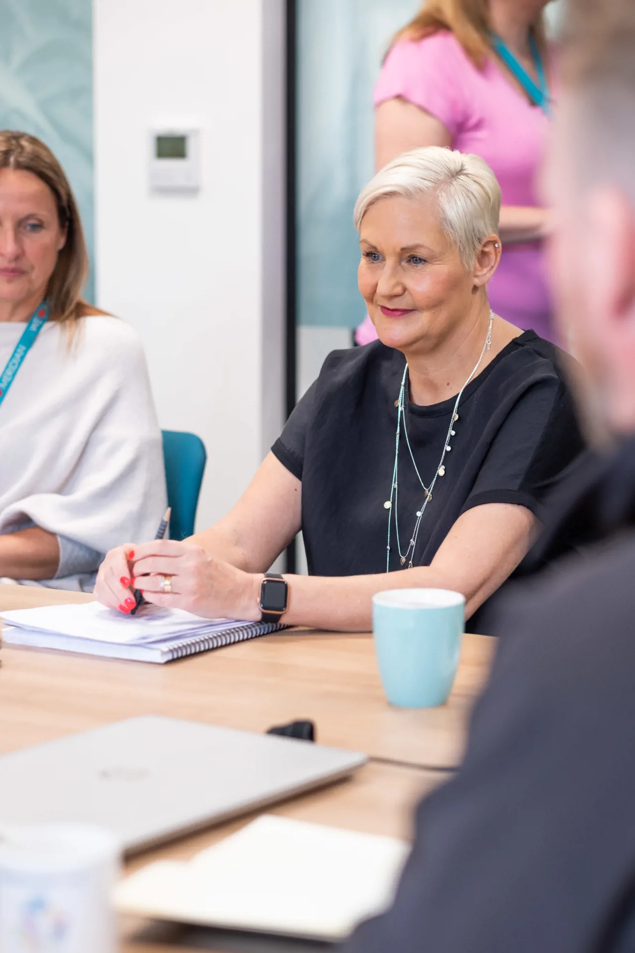 Four senior leadership team members in board room meeting